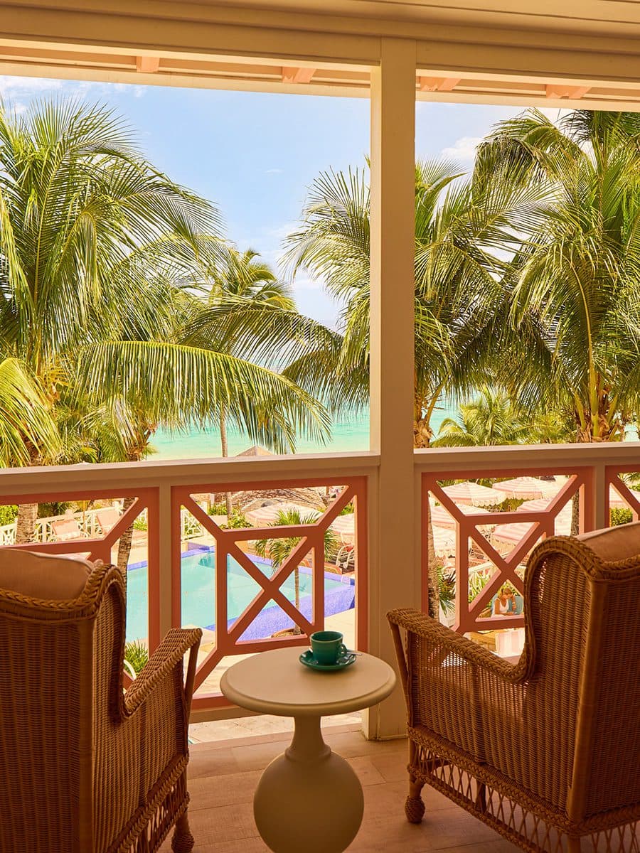 balcony with two rattan chairs overlooking the pool