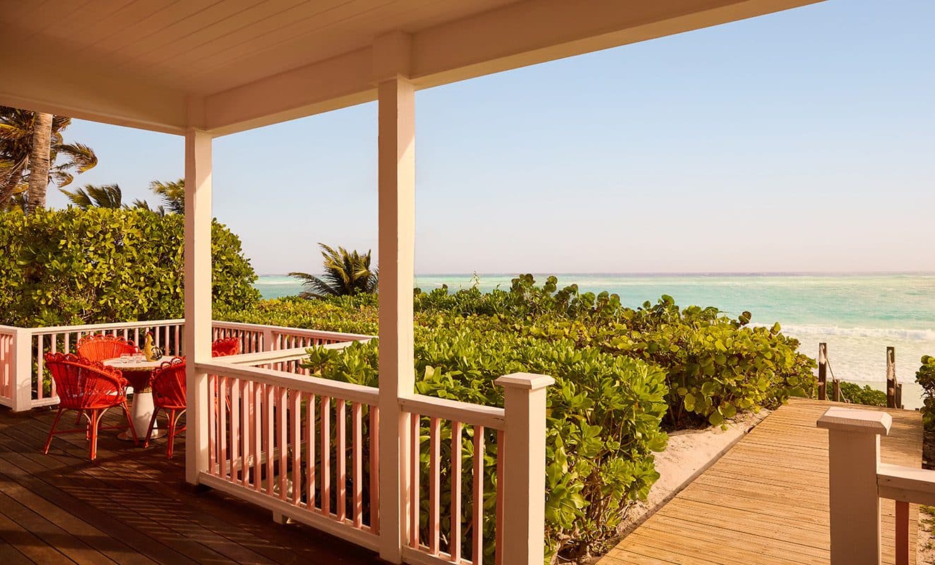 porch with table and chairs overlooking ocean