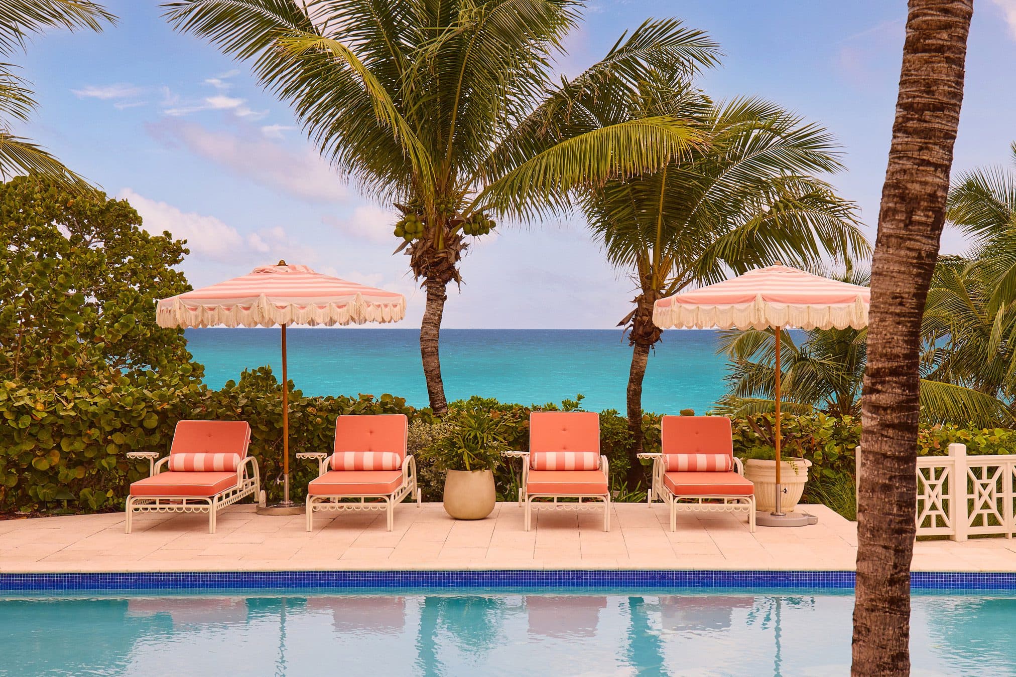 pool with four pink lounge chairs
